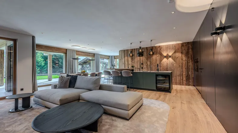 Geräumiger offener Wohnbereich mit moderner Küche, gemütlichem Sofa und Holzakzenten.