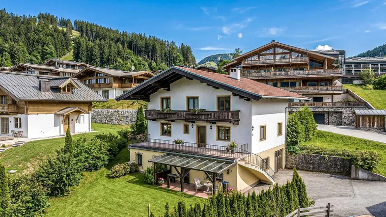 Charmantes Haus mit Garten, überdachter Terrasse und Bergblick in alpiner Umgebung.