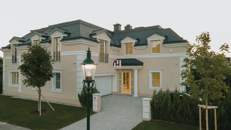 Elegantes Neubauhaus mit gepflegtem Vorgarten und klassischer Architektur.