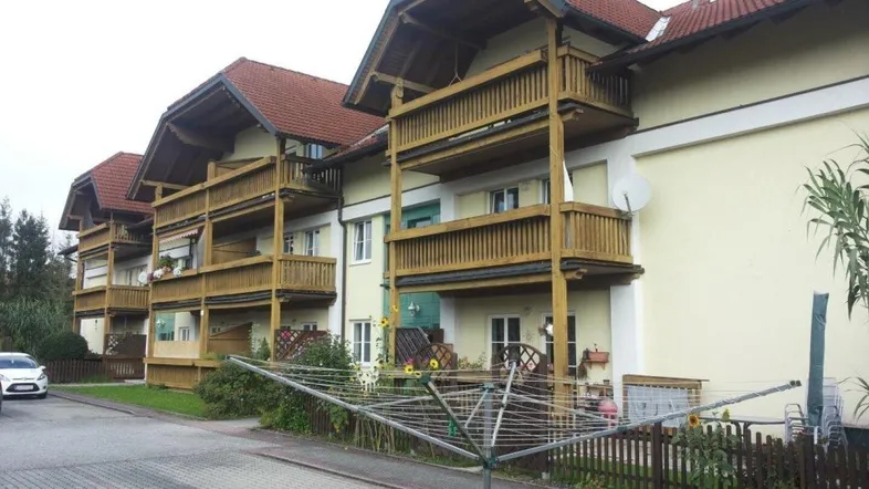 Wohngebäude mit mehreren Balkonen und traditionellem Satteldach in einer ruhigen Wohngegend.