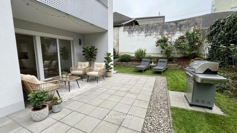 Möblierte Terrasse mit Grillbereich und angrenzendem kleinen Garten, ideal für Entspannung im Freien.
