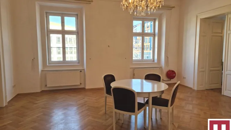 Heller Essbereich mit Fischgrätparkett, hohen Decken und einem eleganten Kronleuchter.