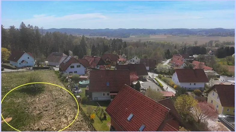 Luftaufnahme eines Wohngebiets mit Häusern und einem markierten Grundstück in ländlicher Umgebung.