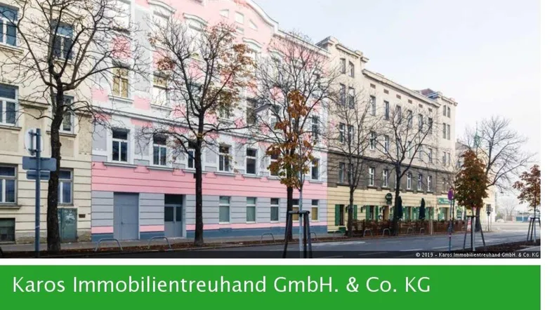 Blick auf eine historische Straße mit mehrstöckigen Gebäuden und kahlen Bäumen im städtischen Umfeld.