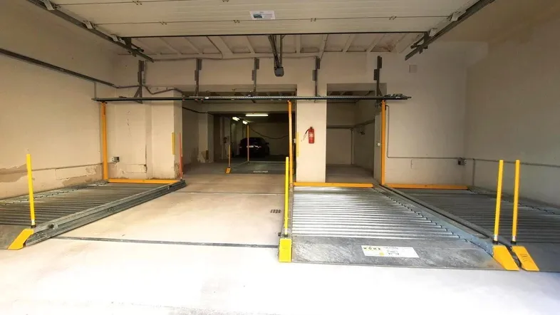 Innenansicht einer Tiefgarage mit zwei automatischen Parksystemen und Brandschutzvorrichtung.
