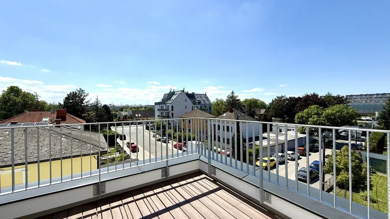 Große Dachterrasse mit Holzboden und Metallgeländer bietet einen weiten Blick über die Umgebung.