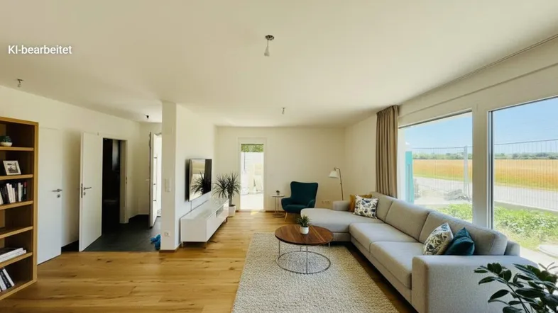 Helles Wohnzimmer mit großem Sofa, Holzboden und weitem Blick ins Grüne durch bodentiefe Fenster.