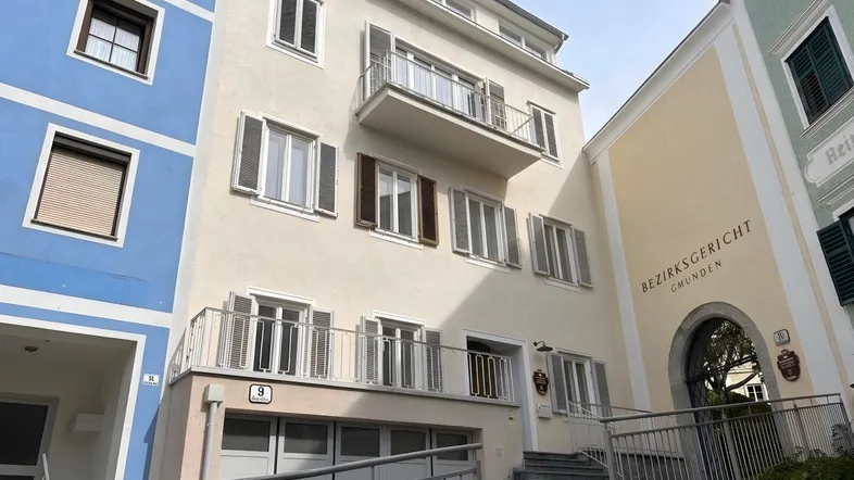 Fassade eines Mehrfamilienhauses mit Balkonen und Fensterläden in Gmunden.