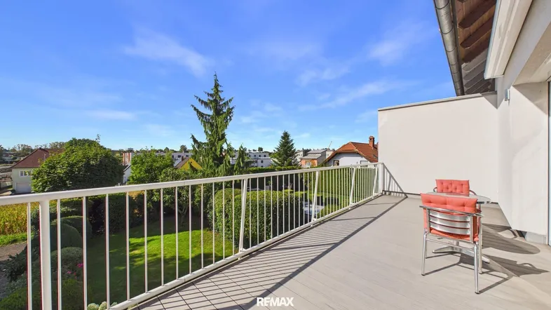 Langer Balkon mit Holzdeck und weißem Geländer bietet weite Aussicht über die Umgebung.