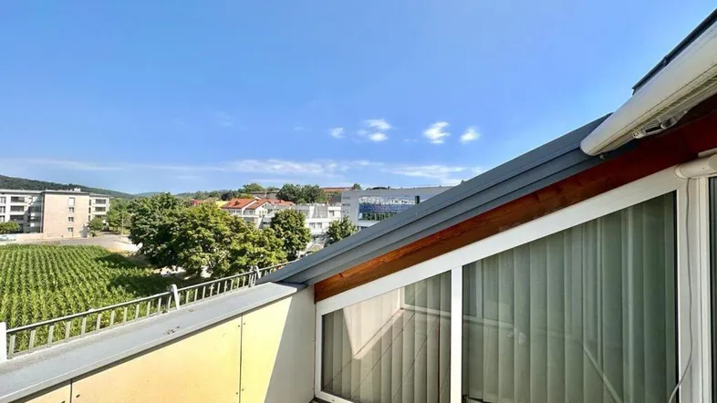 Heller Balkon mit Fliesenboden und weitem Blick über Weinberge und die Umgebung.