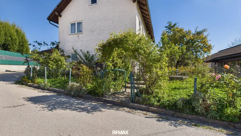 Ansicht des Hauses von der Straße mit gepflegtem Vorgarten und sonnigem Wetter.