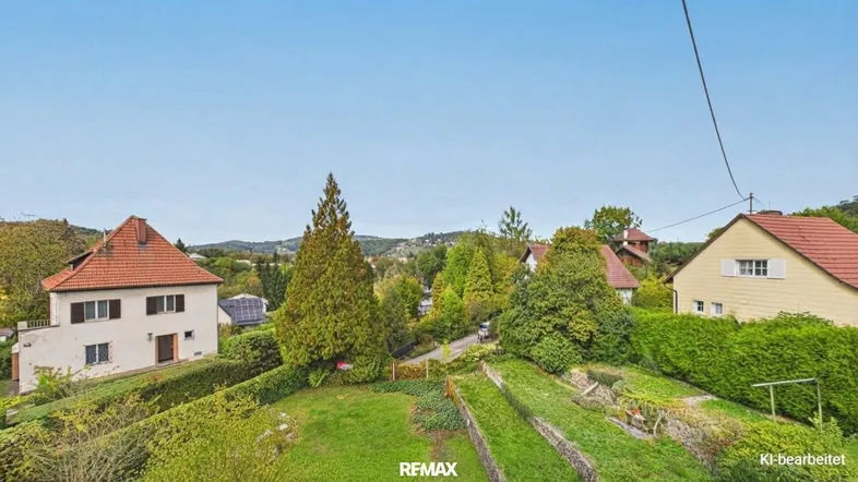 Panoramablick über die grüne Wohngegend mit mehreren Häusern und hügeliger Landschaft.