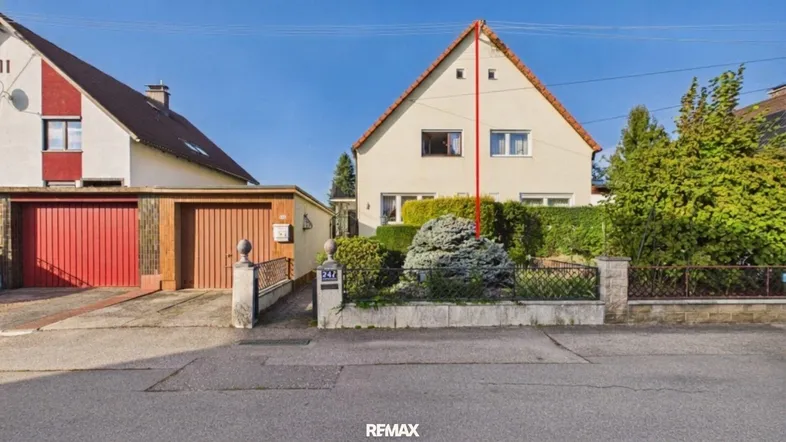 Vorderansicht des Einfamilienhauses mit Vorgarten, Garage und Zufahrt von der Straße aus.
