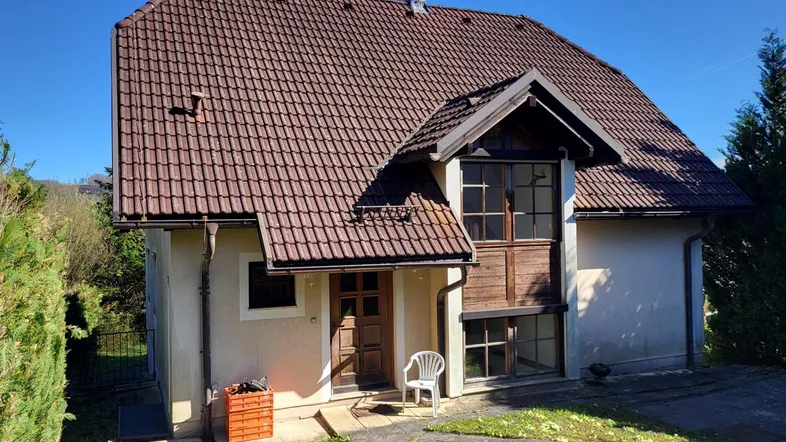 Einfamilienhaus mit Satteldach, kleiner Veranda im Eingangsbereich und gepflegtem Vorgarten.