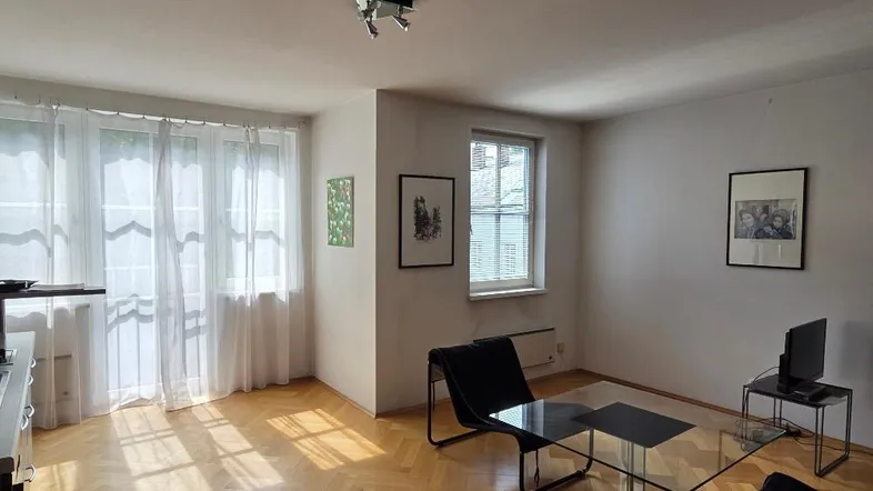 Helles Wohnzimmer mit Fischgrätparkett, großen Fenstern und moderner Einrichtung.