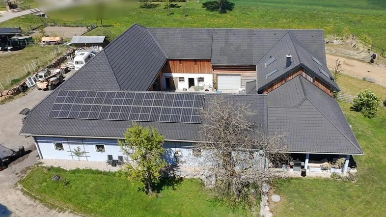 Luftaufnahme des Anwesens mit großem Dach und installierter Photovoltaikanlage auf dem Dach.