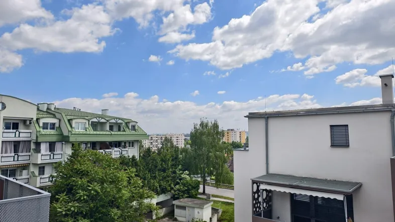 Blick auf die umliegenden Gebäude und die grüne Umgebung unter einem bewölkten Himmel.