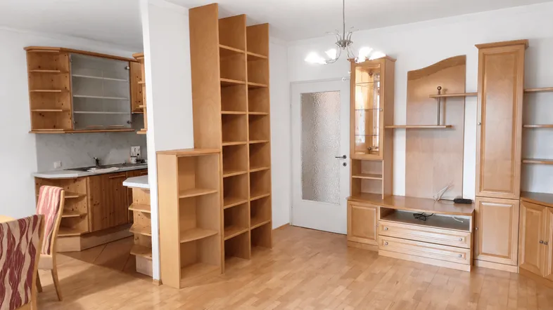 Heller Wohn- und Essbereich mit Holzmöbeln, Parkettboden und integrierter Küche.