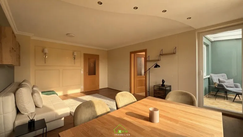 Helles Wohn- und Esszimmer mit Holzboden und Zugang zum Wintergarten.