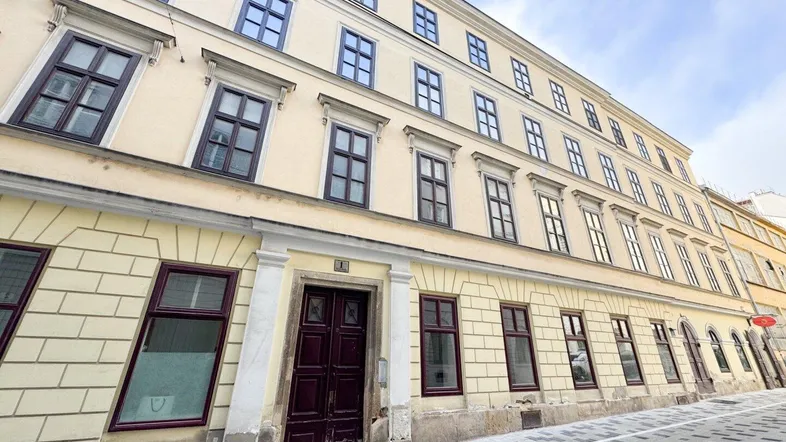 Historische Fassade eines Altbaus mit vielen Fenstern und klassischer Architektur.