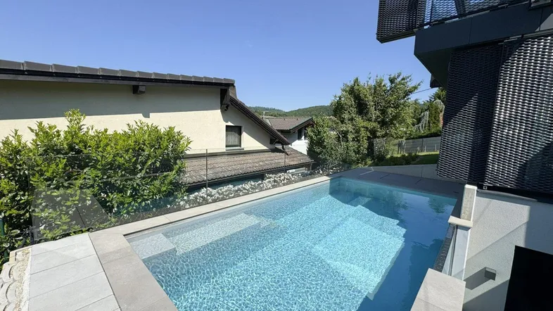 Moderner Außenpool mit klarem Wasser und Blick auf die umliegende Landschaft.