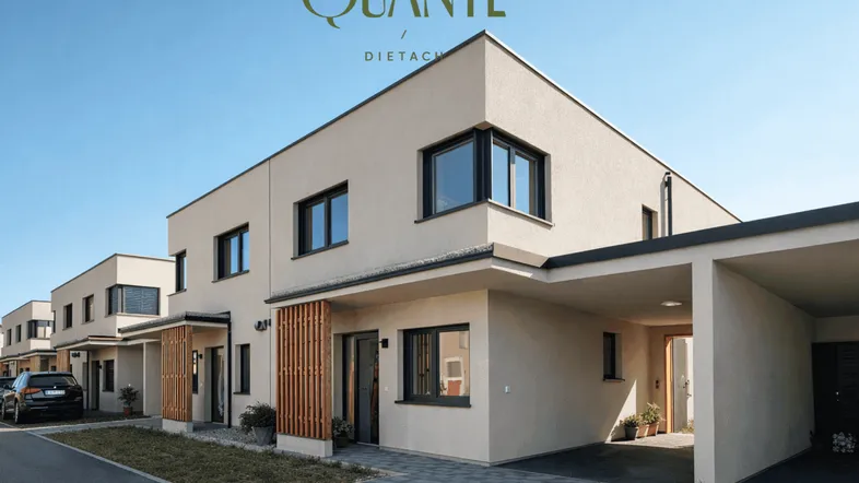 Moderne Reihenhäuser mit heller Fassade, großen Fenstern und integrierten Carports unter blauem Himmel.