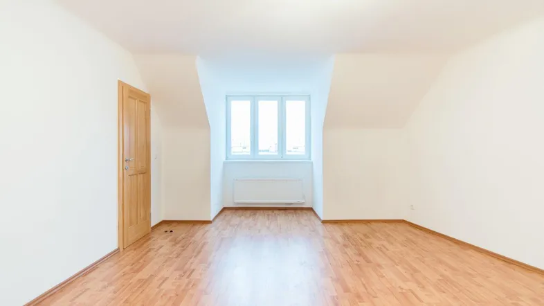 Lichtdurchflutetes Zimmer mit Laminatboden und Dachschräge, bietet viel Potenzial für neue Mieter.