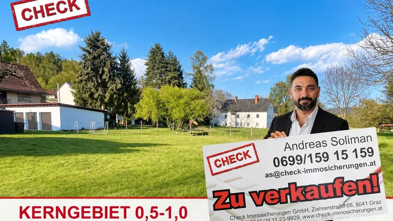 Großes grünes Grundstück mit weitem Rasen und umliegenden Gebäuden unter blauem Himmel.
