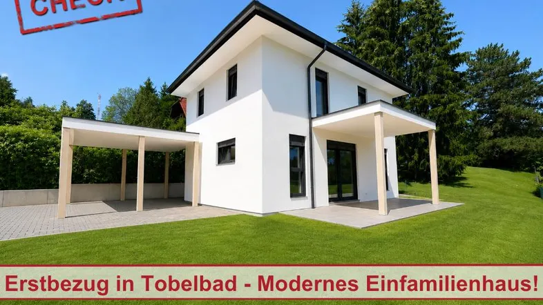 Modernes Einfamilienhaus mit weißer Fassade, Carport und gepflegtem Rasen in sonniger Lage.