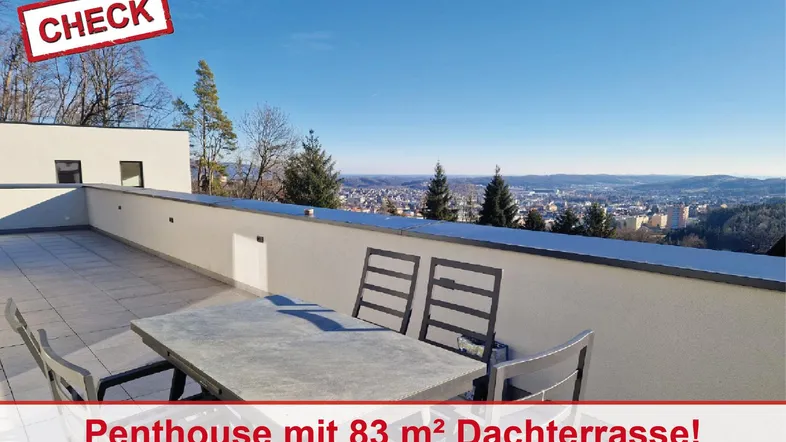 Große Dachterrasse mit Essbereich und weitem Blick über die Stadt und Landschaft.