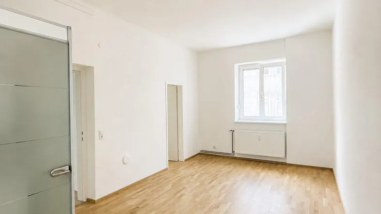 Helles, modernisiertes Zimmer mit Parkettboden und weiß gestrichenen Wänden, bereit zum Einzug.