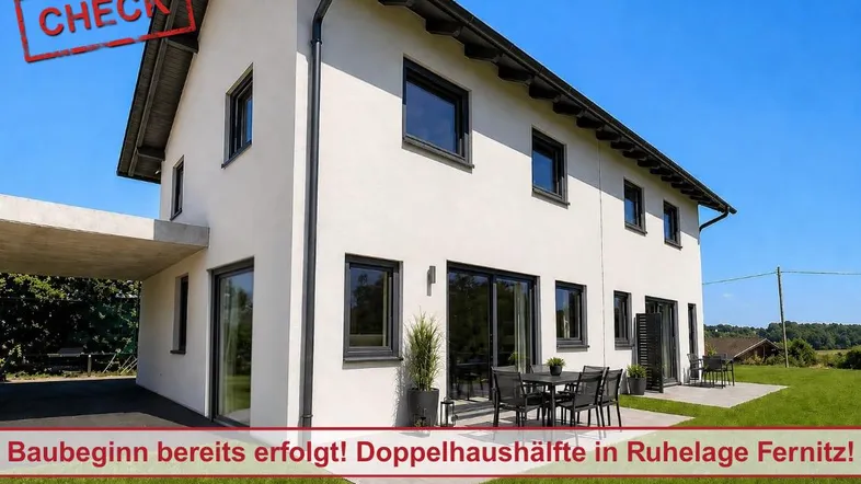 Moderne Doppelhaushälfte mit weißer Fassade, schwarzen Fenstern und einer möblierten Terrasse.
