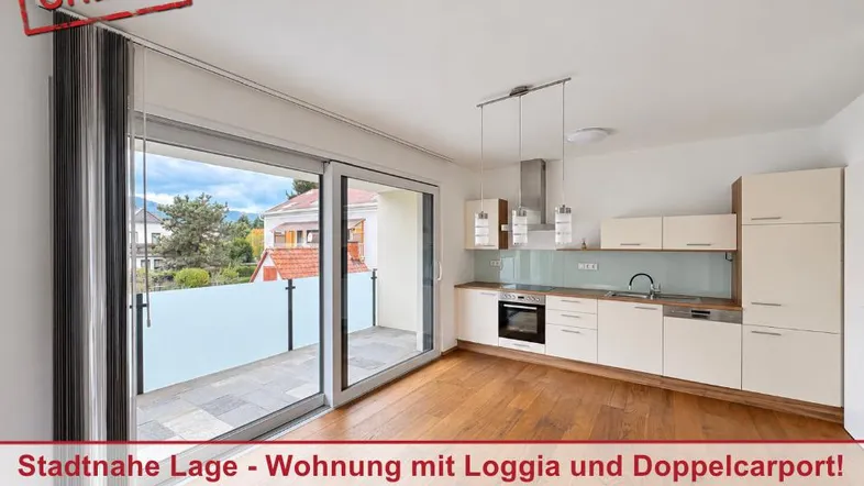 Heller offener Wohn-Essbereich mit moderner Einbauküche und direktem Zugang zu einer geräumigen Loggia.
