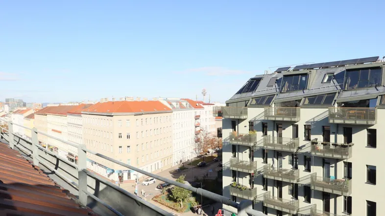 Panoramablick über die Stadt von einem Dach aus, mit modernen Gebäuden und traditionellen Dächern.