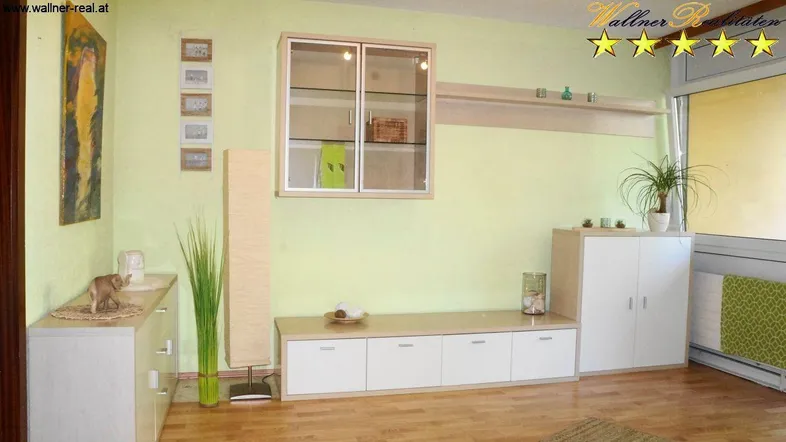 Helles Wohnzimmer mit hellgrünen Wänden, Holzfußboden und modernen Möbeln.