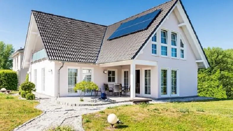 Modernes Einfamilienhaus mit Satteldach, Photovoltaikanlage und gepflegtem Garten mit Terrasse.