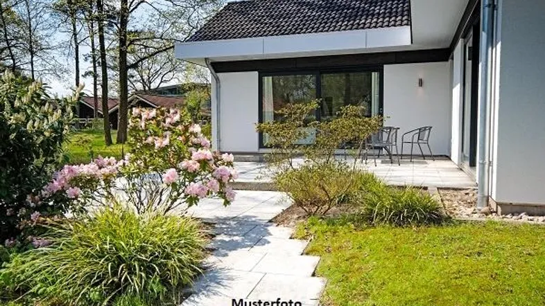 Moderne Terrasse mit Gartenmöbeln und blühenden Pflanzen in einem gepflegten Garten.