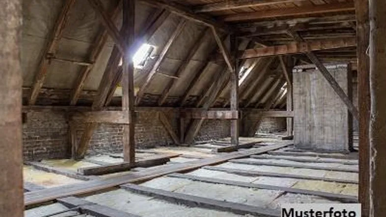 Unfertiger Dachboden mit sichtbaren Holzbalken und Isolierung, bereit für einen möglichen Ausbau.