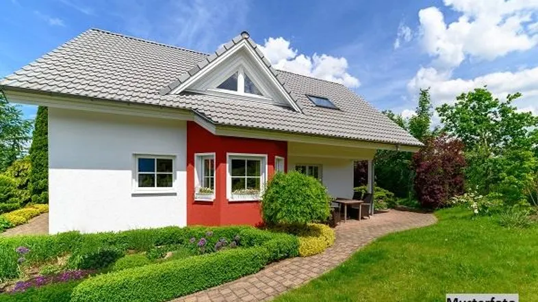 Modernes Einfamilienhaus mit roter Akzentfassade, gepflegtem Garten und kleiner Terrasse.