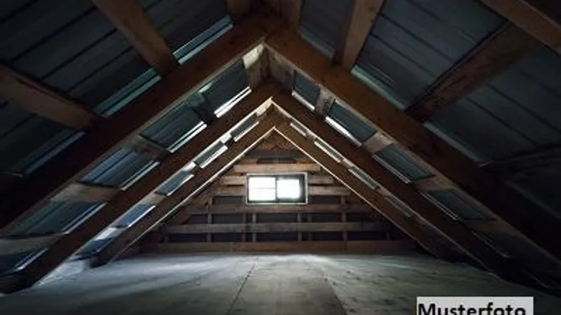 Geräumiger Dachboden mit sichtbaren Holzbalken und einem kleinen Fenster, das natürliches Licht hereinlässt.