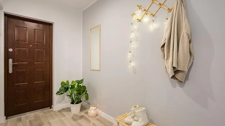 Heller Eingangsbereich mit Holztür, Garderobe und modernem Laminatboden.