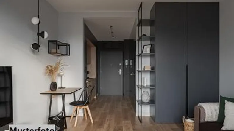 Modern eingerichteter Wohnbereich mit dunklen Einbauschränken, Holzboden und stilvoller Beleuchtung.