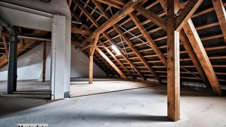 Geräumiger Dachboden mit sichtbaren Holzbalken und Betonboden, ideal für einen zukünftigen Ausbau.