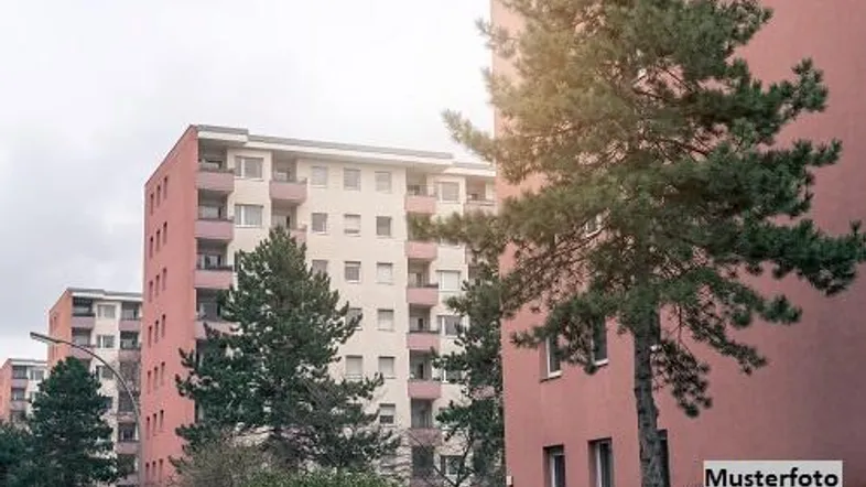 Mehrere Mehrfamilienhäuser mit rosa Fassaden und Bäumen in einer Wohnsiedlung.