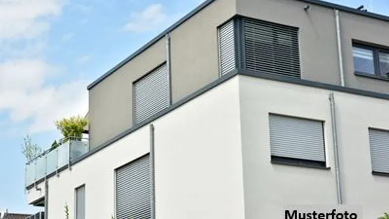 Moderne Fassade eines Mehrfamilienhauses mit Flachdach und Rollläden an den Fenstern.