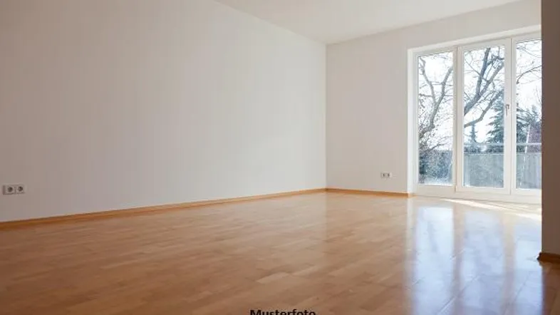 Heller, leerer Raum mit glänzendem Parkettboden und großen Fenstern, bereit zum Einzug.