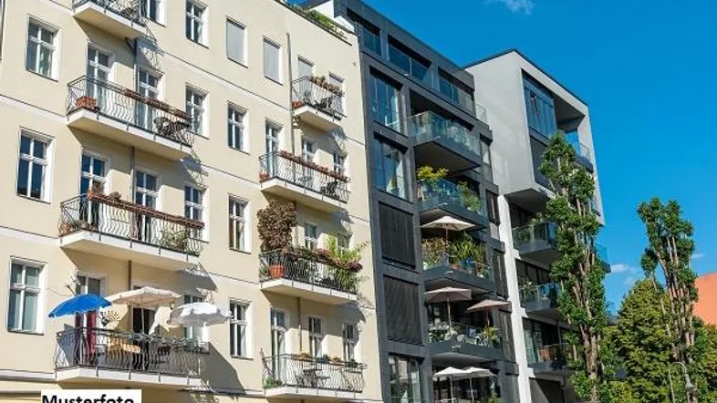 Fassade eines modernen und eines klassischen Wohngebäudes mit zahlreichen Balkonen unter blauem Himmel.