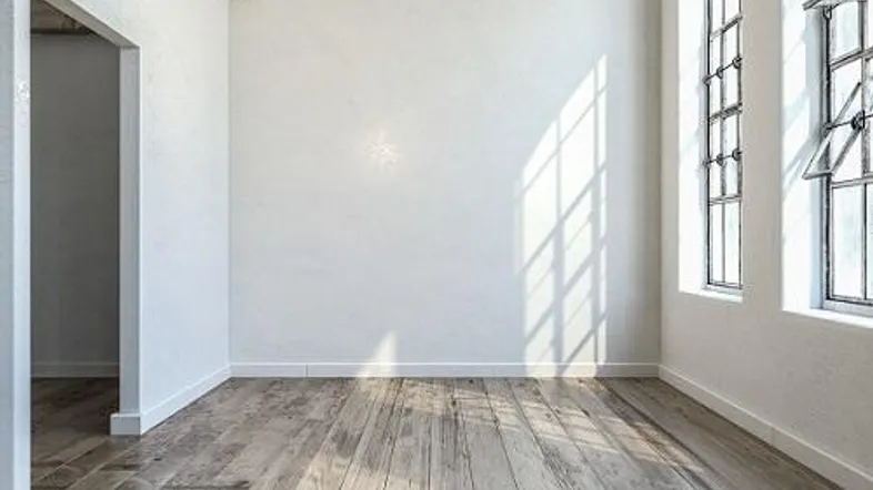 Heller, leerer Raum mit hohen Decken, Holzboden und großen Fenstern, ideal für ein modernes Wohnambiente.