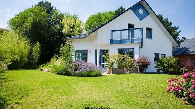Weißes Einfamilienhaus mit blau akzentuierter Fassade, grünem Garten und kleinem Balkon.