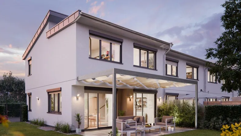 Moderne Doppelhaushälfte mit überdachter Terrasse und Gartenbereich bei Sonnenuntergang.
